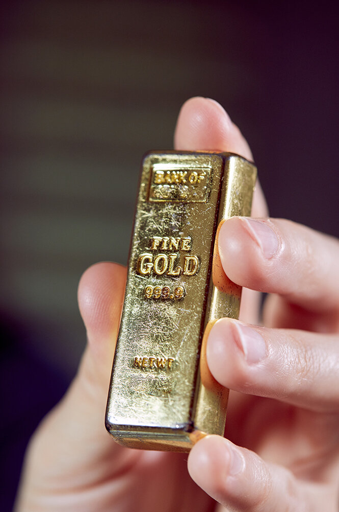 kleiner Goldbarren in einer Hand